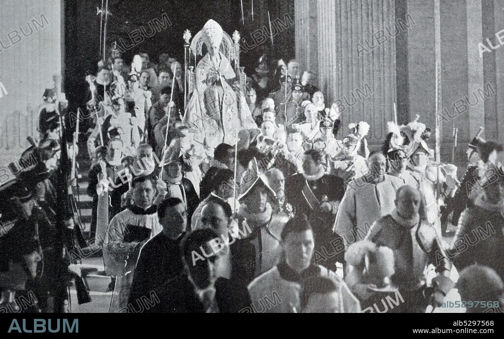Black and white photograph of the coronation of Pope Pius XII (1876-1958; pope from 1939); the new pope is carried in on a litter in St. Peter's Basilica.