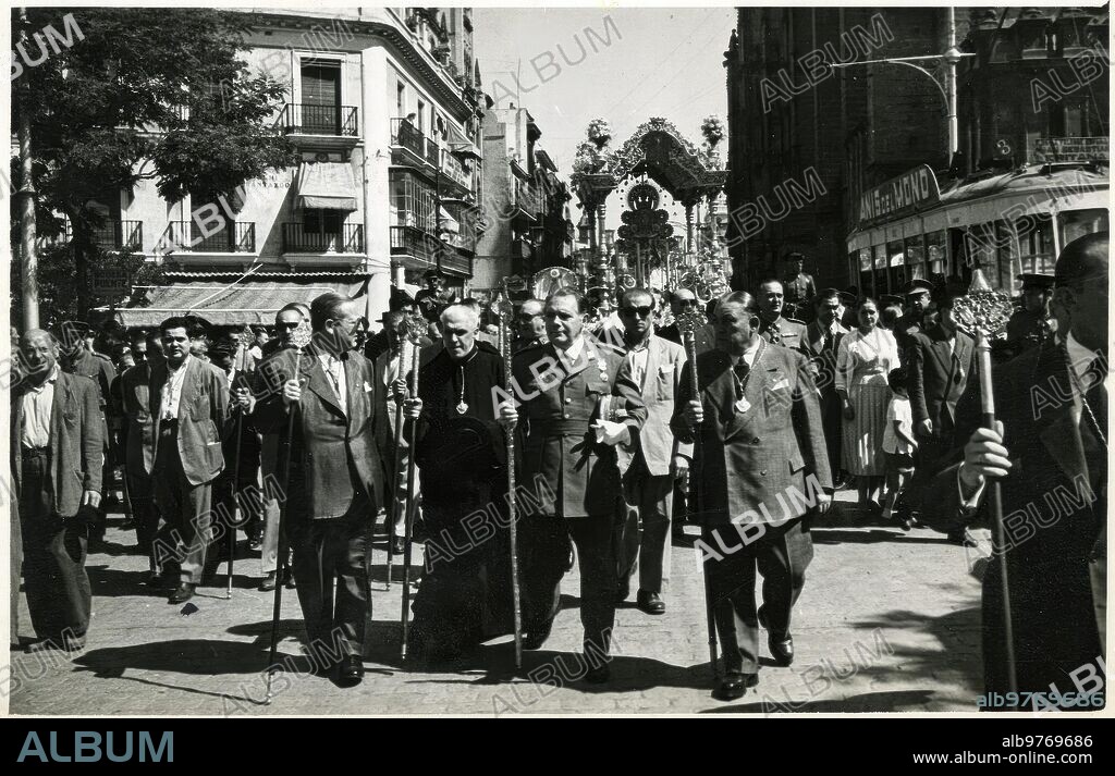 Rocío   rocío 09. En 1957, el teniente general Antonio Castejón Espinosa Había Relevado al teniente general Eduardo Sáenz de Buruaga al mando de la capitanía general de la Ii región Militar, con sede en Sevilla. Desde la primera Época, la hermandad del rocío de Sevilla Nombró hermano mayor honorario al capitán general de Tierra, del mismo modo que el capitán general de la región militar Aérea era distinguido como hermano mayor honorario de la hermandad del rocío de Triana. En la Imagen, el general Castejón figura en la presidencia de la hermandad del Salvador, A su paso por la Avenida. El sacerdote Podría ser Félix Royo, director espiritual de la Hermandad. Era hermano mayor José María Domenech Romero. La instantánea Rezuma Grandísimo Sabor. La esquina de la calle Almirantazgo, tan Distinta A la Actual; El tranvía Que, con la propaganda De «anís del Mono», Viene desde Eritaña; El poste tan discreto para los Cables del Tranvía; La Virgen del rocío del Salvador en la carreta del Simpecado. Otros Tiempos. Serrano.