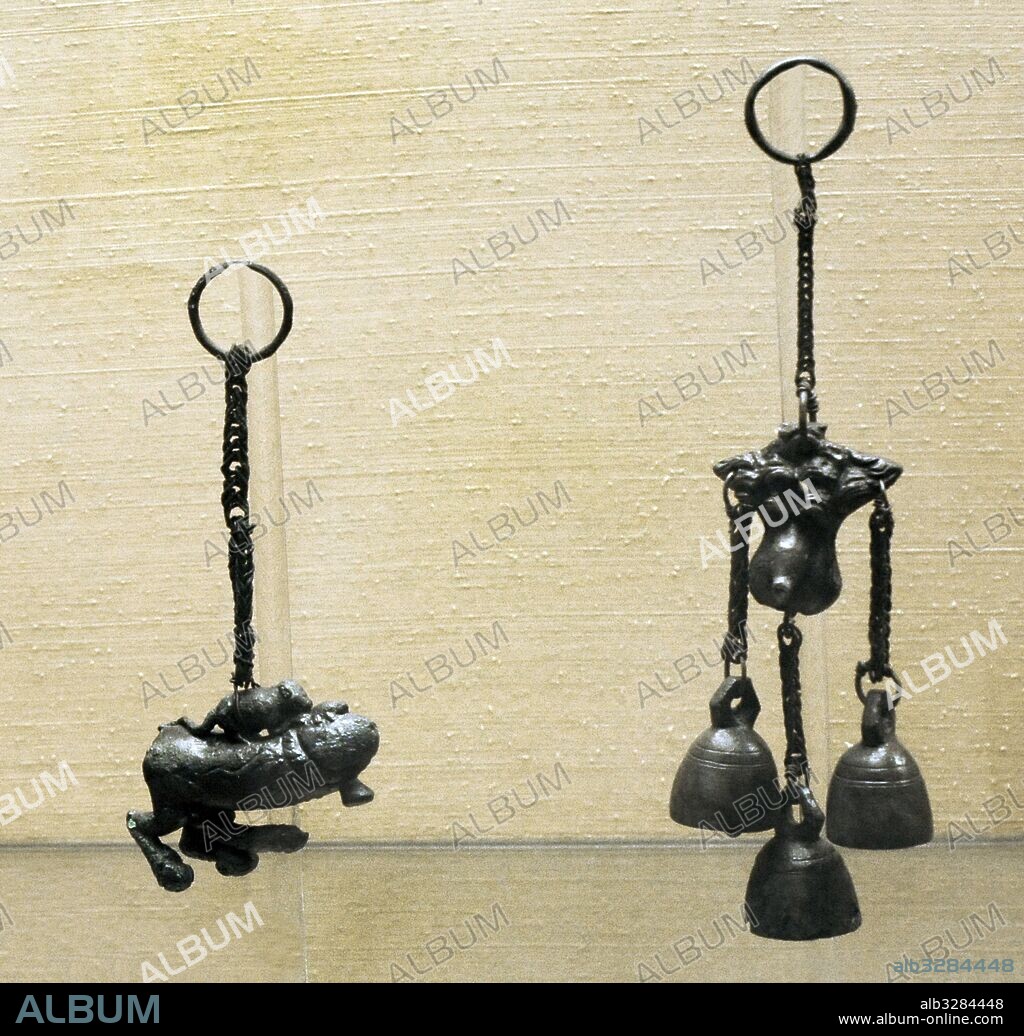 Tintinnabulum o tintinábulo, campanilla de viento o conjunto de campanillas, normalmente en forma fálica, pensado para protegrese del mal de ojo. De izquierda a derecha: Tintinnabulum de bronce en forma de falo ratón y tortuga. Pompeya, Siglo I d. C. Tintinnabulum de bronce procedente de Herculano, siglo I d. C. Museo Arqueológico Nacional. Nápoles. Italia.