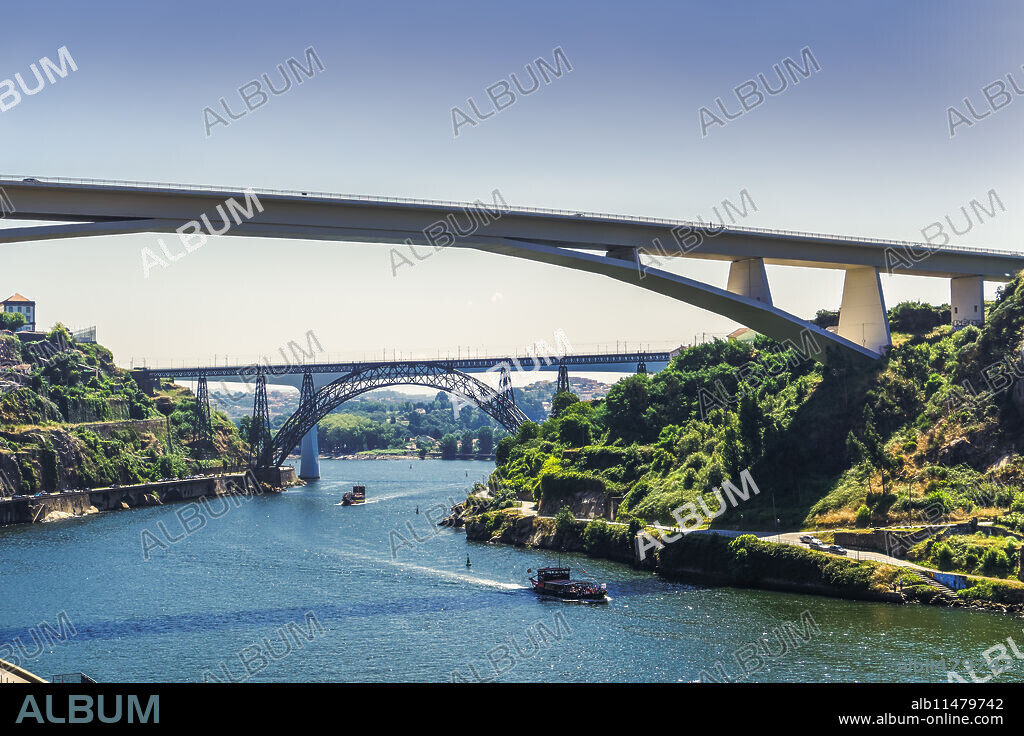View of three bridges over Douro River with tourist ships in front of Infante D. Henrique, Maria Pia and St. John bridges, Porto, Portugal, Europe.