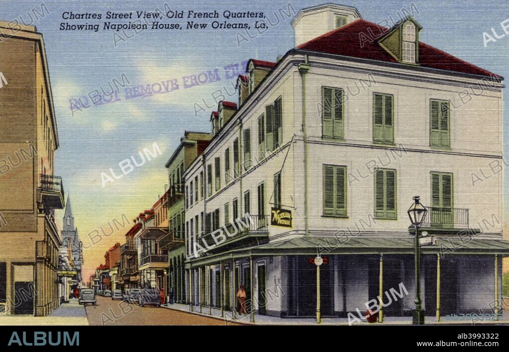 Chartres Street, old French Quarter, New Orleans, Louisiana, USA, 1940. Postcard. View showing Napoleon House on the corner of Chartres Street. Cars are parked along the street and a church is visible in the distance. Built in 1797, Napoleon House derived its name from a local story that it was intended to be the former French Emperor's residence after his exile. The building served as the residence of the Mayor of New Orleans, Nicholas Girod, between 1812 and 1815. Since the end of the Prohibition era it has housed a bar called the Napoleon House.