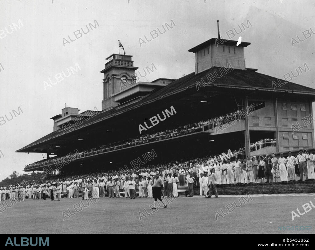 Front view of two tier stand at the Singapore Turf club course. Patrons have comfortable seats, and arm rests, to watch races. Membership of club 10,000; costs 10 dollars (£1/10/-) a year. December 1, 1950.