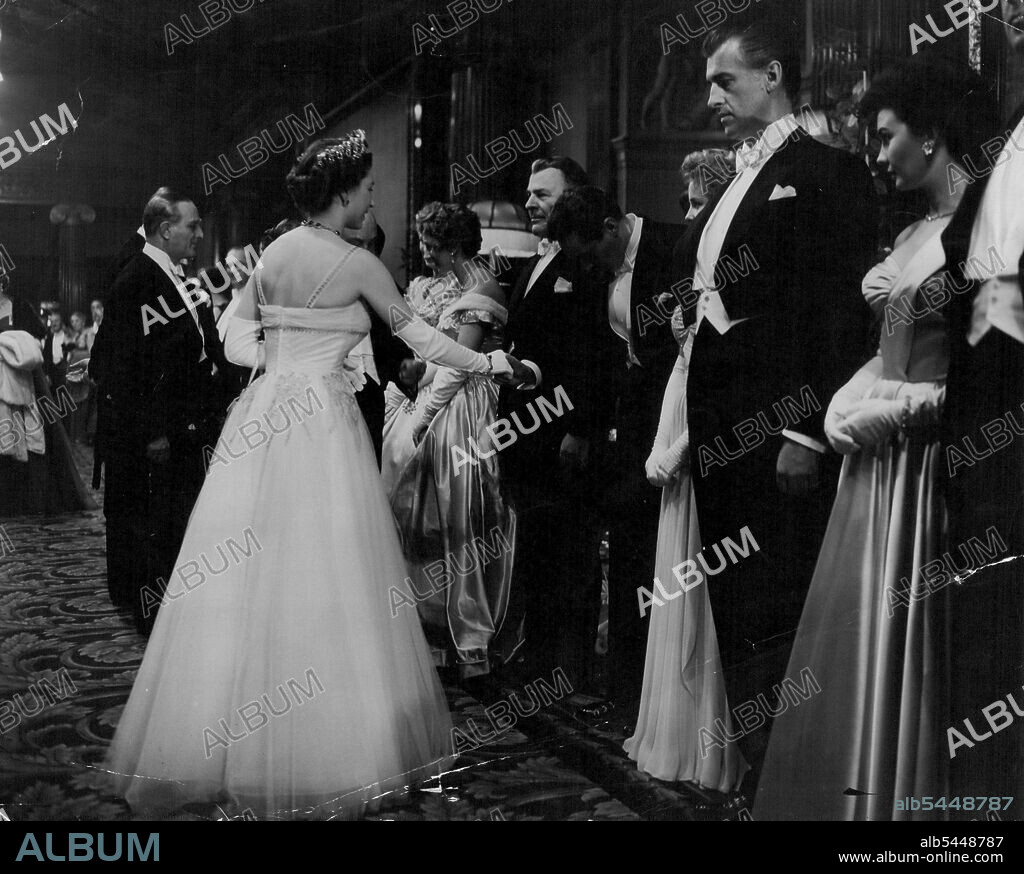 The Royal Film Performance -- H.M. The Queen shaking hands with Peter Finch also seen are Brian Donlevy and Stewart Granger and Jean Simmons. H.M. The Queen, The Duke of Edinburgh and Princess Margaret attended tonight's (London) presentation of M.G.M.'s "Beau Brummell" at the Empire Theatre, London. The film, produced at Elstree, stars Stewart Granger, Elizabeth Taylor, Peter Ustinov an Robert Morley. November 15, 1954. (Photo by L.N.A.).