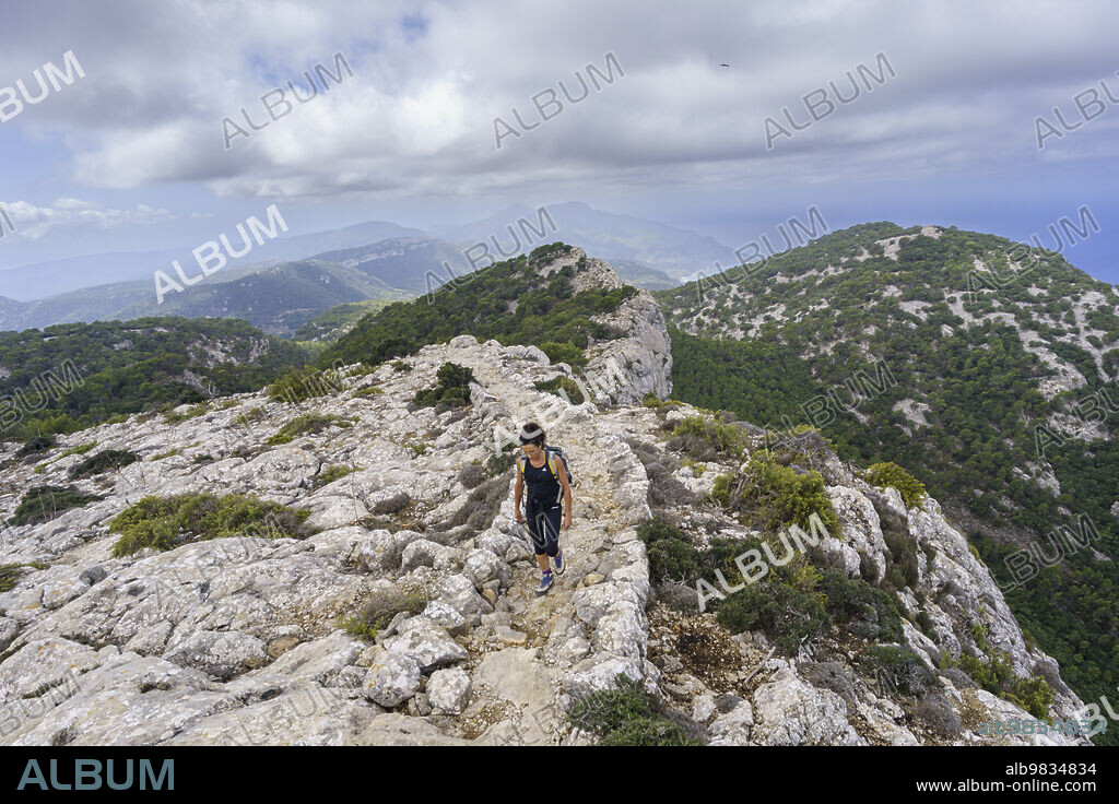 middle-aged woman walking Camí de s'Arxiduc route, Valldemossa, Majorca, Balearic Islands, Spain.