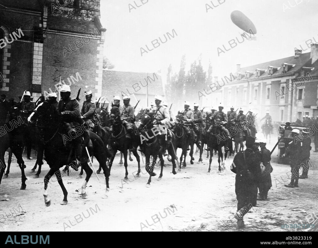 French soldiers on horseback in street, with an airship flying in air behind them during World War I. Cavalry or horsemen were soldiers or warriors who fought mounted on horseback. A soldier in the cavalry is known by a number of designations such as cavalryman, horseman or trooper. In August 1914 all combatant armies still retained substantial numbers of cavalry and the mobile nature of the opening battles on both Eastern and Western Fronts provided a number of instances of traditional cavalry actions, though on a smaller and more scattered scale than those of previous wars. Once the front lines stabilized on the Western Front, a combination of barbed wire, machine guns and rapid fire rifles proved deadly to horse mounted troops. The Germans, French and Italians all used airships for scouting and tactical bombing roles early in the war, and all learned that the airship was too vulnerable for operations over the front. Bain News Service circa 1914/15.