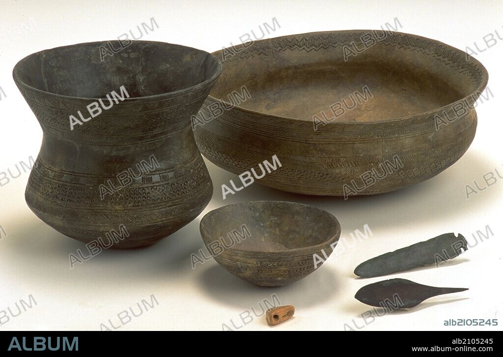 CONJUNTO. CUENCO DE MADRID, VASO CAMPANIFORME DE PALENCIA, PUNTA PALMELA DE VELEZ MALAGA, CUCHILLO DE LOMA DE LA ATALAYA, BOTON DE PERFORACION EN V Y CAZUELA. BRONCE S.V a.C. (DEPOSITO: MUSEO ARQUEOLOGICO NACIONAL).