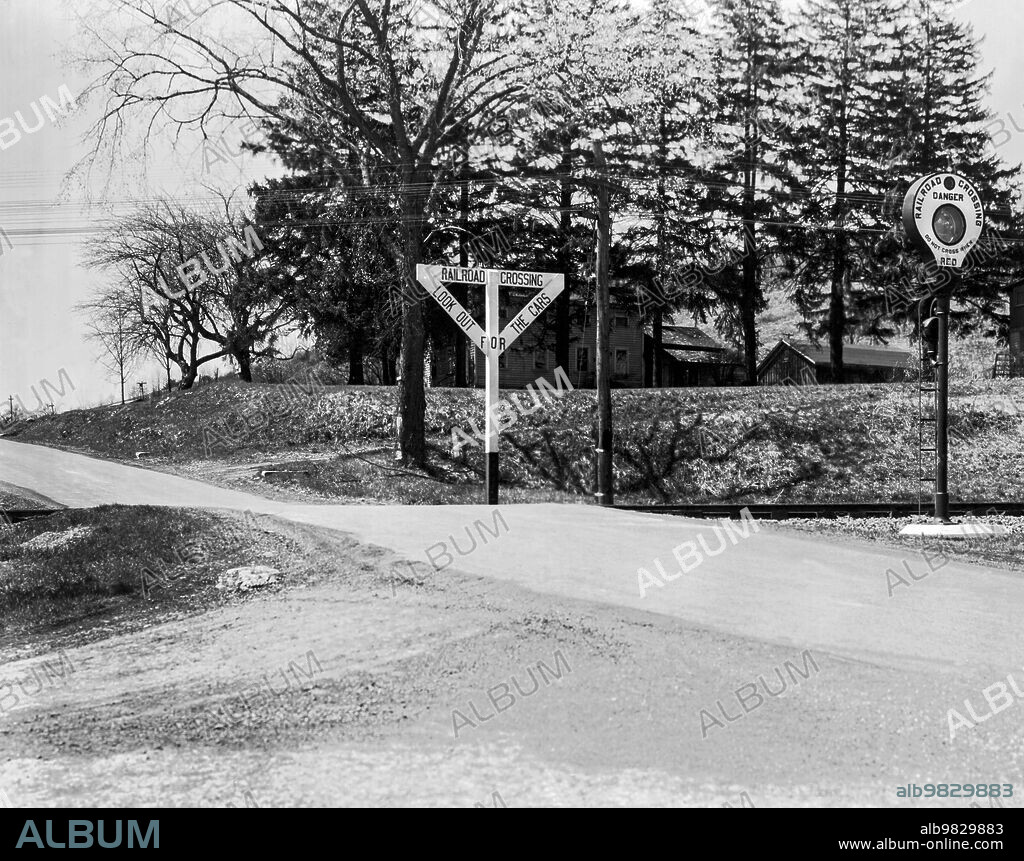 New York April, 1941, A rural railroad crossing for the Lehigh Valley Railroad with warning lights and signs.