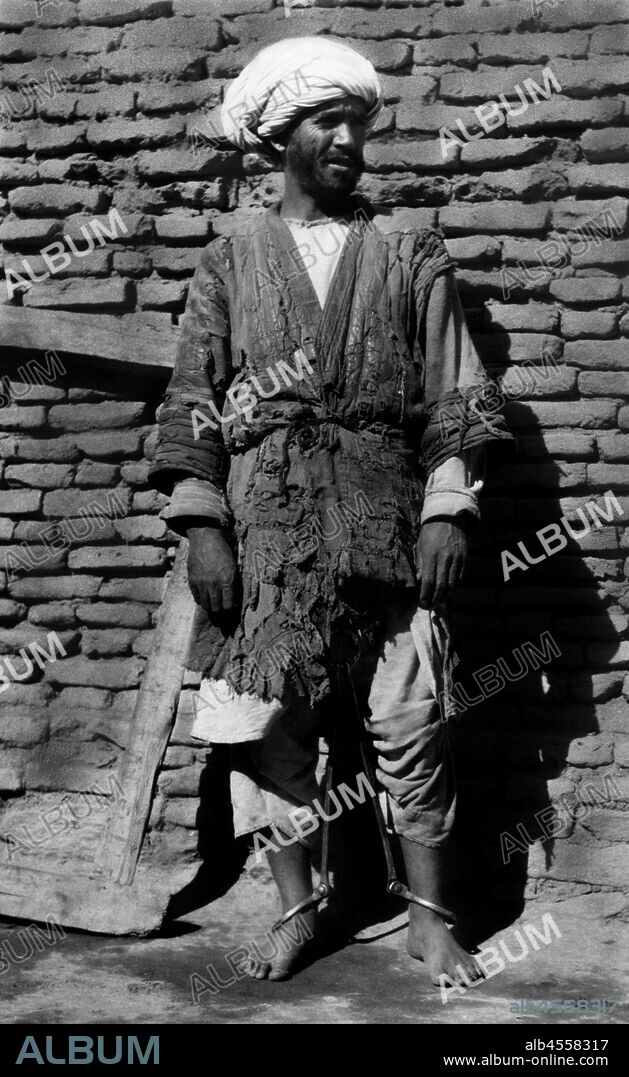 Afghanistan. an Afghan prisoner with legs bound by a metal device. 1920-30.