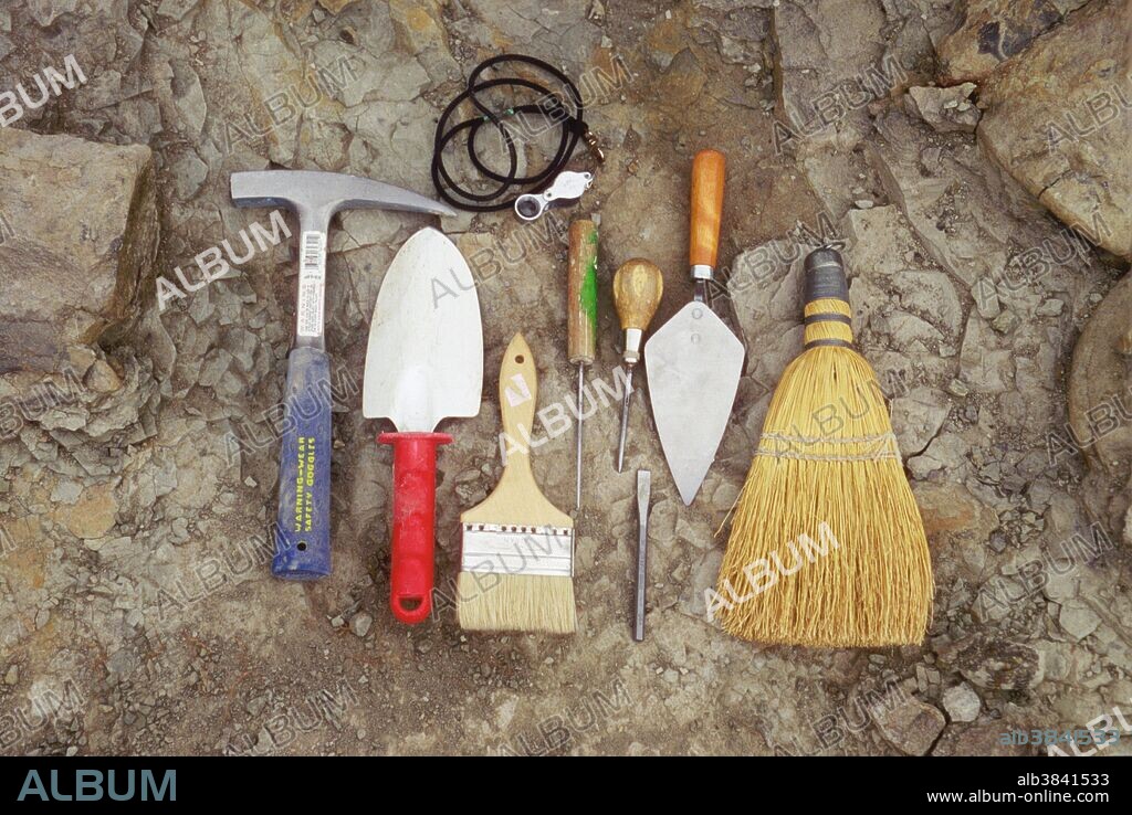 A display of the common tools used to excavate dinosaur fossils. These include a rock hammer, trowel, paintbrush (to remove dust) an ice pick, a cement trowel, a hand brush, and a loupe.
