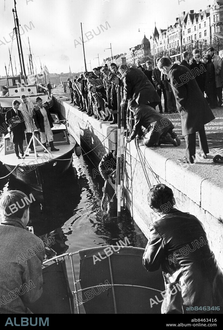 STOCKHOLM 19661028 - Träskmorden i Stockholm. Den mördade Siv Gryting bärgas av grodmän ur Nybroviken. Siv gryting var ett av tre offer för gärningsmannen Hans Marmbo. De övriga två offren dumpades på andra platser i Stockholm. Namnet "Träskmorden" kommer från de skumraskkvarter runt Brunnsgatan där morden utfördes. . Foto: Jonny Graan / EXP / Kod: 16 . COPYRIGHT SCANPIX SWEDEN.