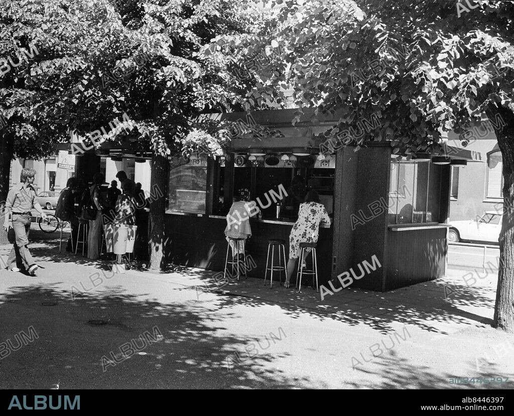 STOCKHOLM 1976-06-28. I Kungsträdgården finns det berömda Almfiket, men också Piccolino, ett sydländskt litet café i höjd med scenen. Där sitter du vid bardisken och det ärdärför en ström av människor som går och kommer. Öppet alla dagar kl 1123. Espresso kostar 2.50 kr, cappuccino (kaffe, vispgrädde och kakao) 3.50 kr. Diverse kakor kostar 2 kr.. Foto: Per Kagrell / Expressen / TT / Kod 26. ** AFTONBLADET OUT **.