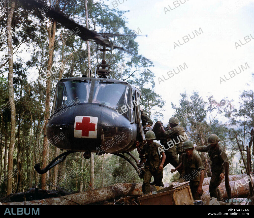 Assault on Hill 875, Vietnam, November 1967: Members of 173d Airborne Brigade load casualties onto a helicopter carrying the emblem of the Red Cross for evacuation to a field hospital.