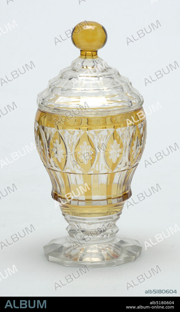 Jar and lid, Glass, Ogee-shaped body on short stem with faceted knop and 12-sided flaring foot; sides cut to reveal clear glass behind flashed amber layer in pattern of rosettes in oval frames and underneath alternate colored vertical stripes; domed, stepped cover, faceted, with amber ball finial., Europe, 19th century, glasswares, Decorative Arts, Jar and lid.