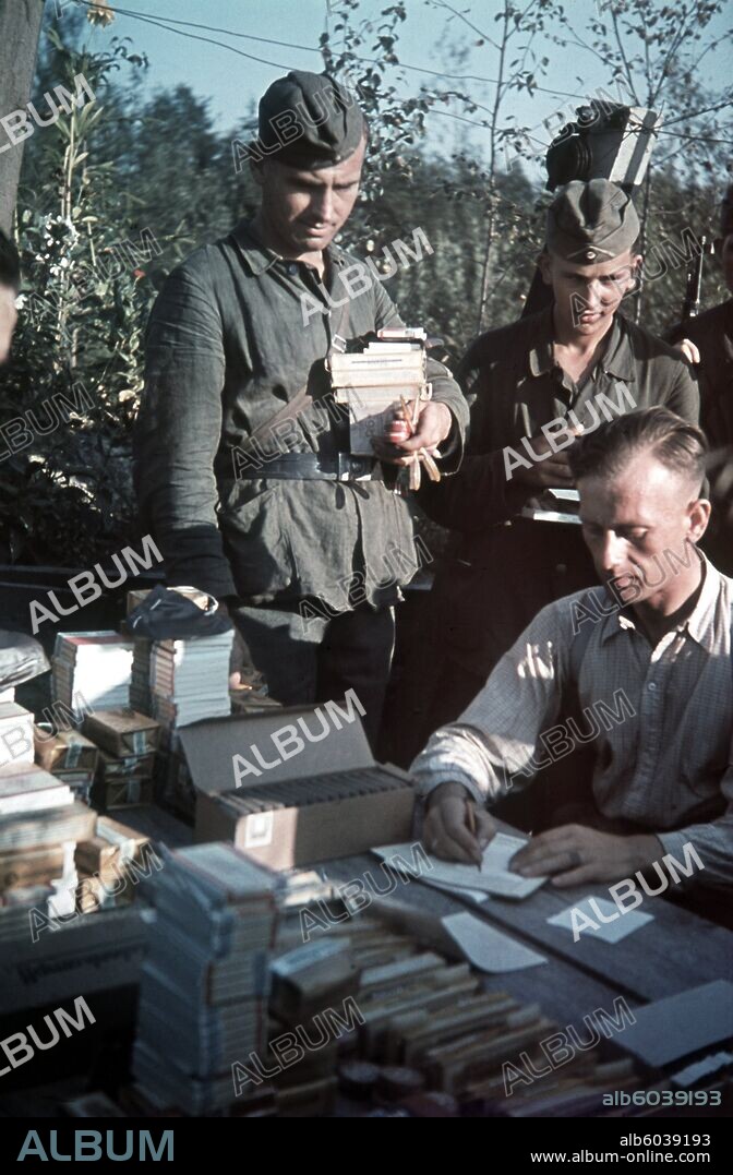 Deutsche Soldaten bei der Ausgabe von Marketender-Waren im Schützengraben im September 1942 während des Russland-Feldzugs im Zweiten Weltkrieg (1939-1945). 31/08/1942