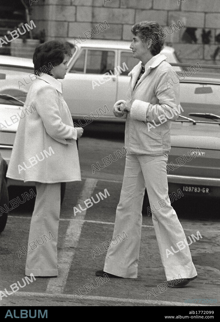 Susanna Agnelli mayor of Monte Argentario. Susanna Agnelli from one years ago mayor of Monte Argentario, photographed in a parking space of the city with a girl; with great commitment the third-born of Edoardo Agnelli she's leading a fight against the property speculation in the Argentario. Monte Argentario (Grosseto) 1975.