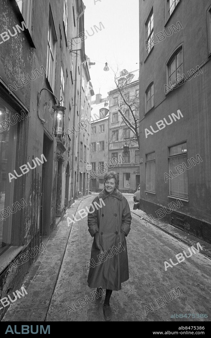 1960-02-02 INFÖR MELODIFESTIVALEN 1960 på Cirkus i Stockholm. Sångerskan Britt Damberg på promenad i Gamla Stan. Bildreportage inför Melodifestivalen 1960. Foto: Jarl Ekenryd / RIR / SVT / Kod:5600 RiR 15327 sv/v neg Ytterkläder Kappor persons: BRITT DAMBERG sites: STOCKHOLM;SVERIGE. Bilden får endast användas i programpresenterande sammanhang. Fotografens namn, Sveriges Television samt programmets titel skall alltid anges.
