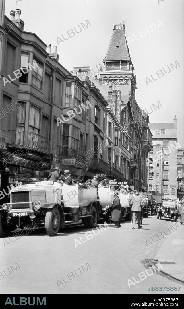 JOHN HARRY PLEDGE. Claremont, Hastings, East Sussex, 1927. Looking north along Claremont, showing a party of holidaymakers climbing into a line of open-topped charabancs.