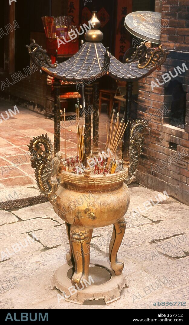 China: Incense urn at the 19th century Man Mo Temple, Tai Po, New Territories, Hong Kong. The temple is dedicated to Man Cheong, the God of Literature, and Mo Tai, the god of Martial Arts.<br/><br/>. Originally a sparsely populated area of farming and fishing villages, Hong Kong has become one of the world's most significant financial centres and commercial ports. It is the world's tenth-largest exporter and ninth-largest importer.<br/><br/>. Hong Kong became a colony of the British Empire after the Qing Empire ceded Hong Kong Island at the end of the First Opium War in 1842.