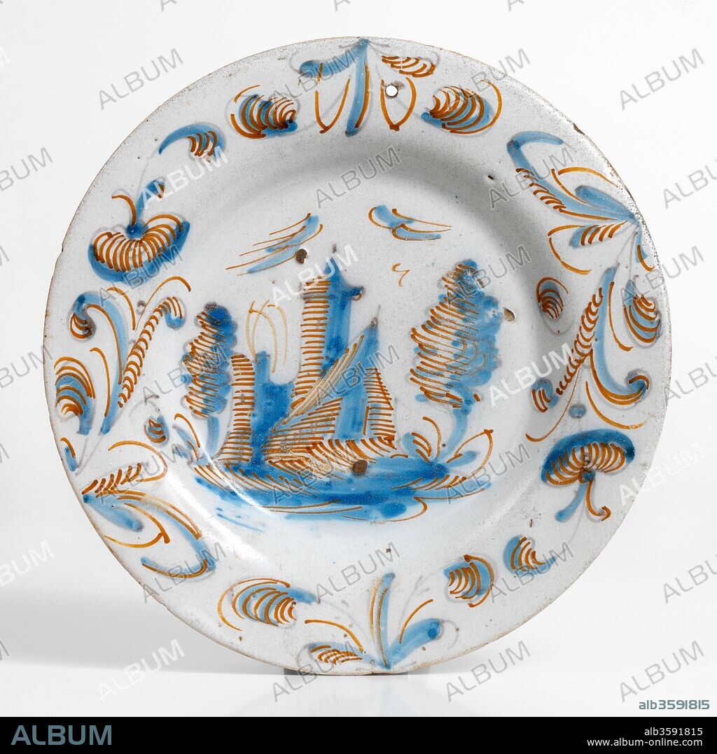 Plato, Siglos XVII Y XVIII, Cerámica (Serie tricolor; loza decorada en azul, naranja y negro, con paisaje con arquitectura y orla de motivos vegetales en forma de voluta), de Talavera de la Reina o Puente del Arzobispo (Toledo), Diámetro: 23,3 cm.