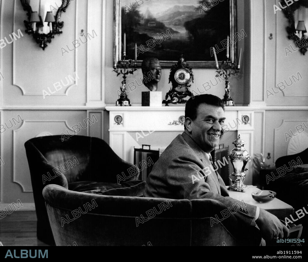 Gino Cervi at home. Italian actor Gino Cervi sitting in the livingroom at home. 26th July 1962.