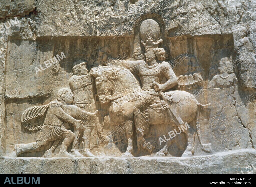 ARTE PERSA-PERIODO SASANIDA. Bajorrelieve del "TRIUNFO DE SEPUR I", donde se narra la rendición de los emperadores VALERIANO y FILIPO "el Arabe" tras las campañas de 252-261. A caballo el rey sasánida y arrodillado ante él, Valeriano, su prisionero hasta su muerte. Relieve del s. III d. C. NAQSH-E ROSTAM (Naqsh-e Rustam). Provincia de Fars. República Islámica de Irán.