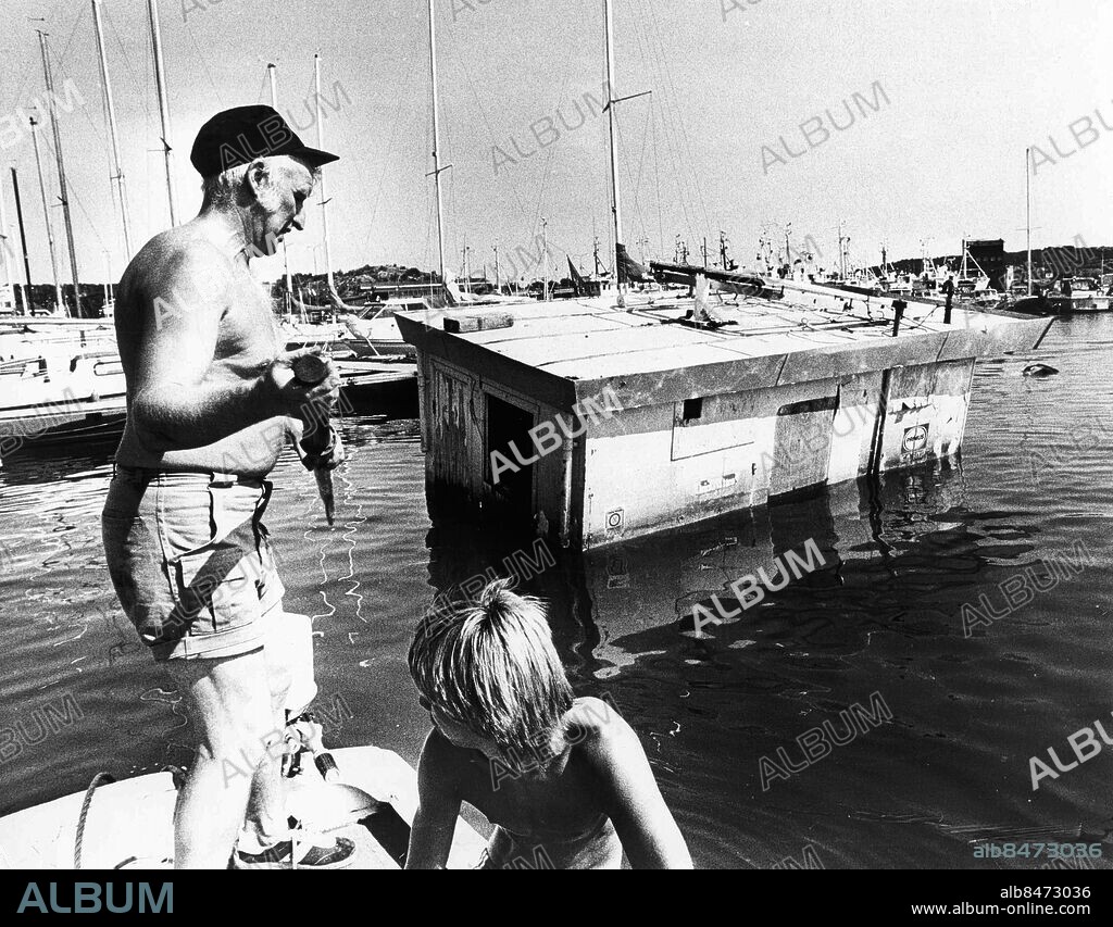 Göteborg 1982-08-06. Hamnvakterna Lars Holmgren och Allan Perkäkylä framför den sjunkna bensinmacken i Fiskebäcks småbåtshamn *** Local Caption *** GP Foto: Claes Franzén. KAMERAREPORTAGE.