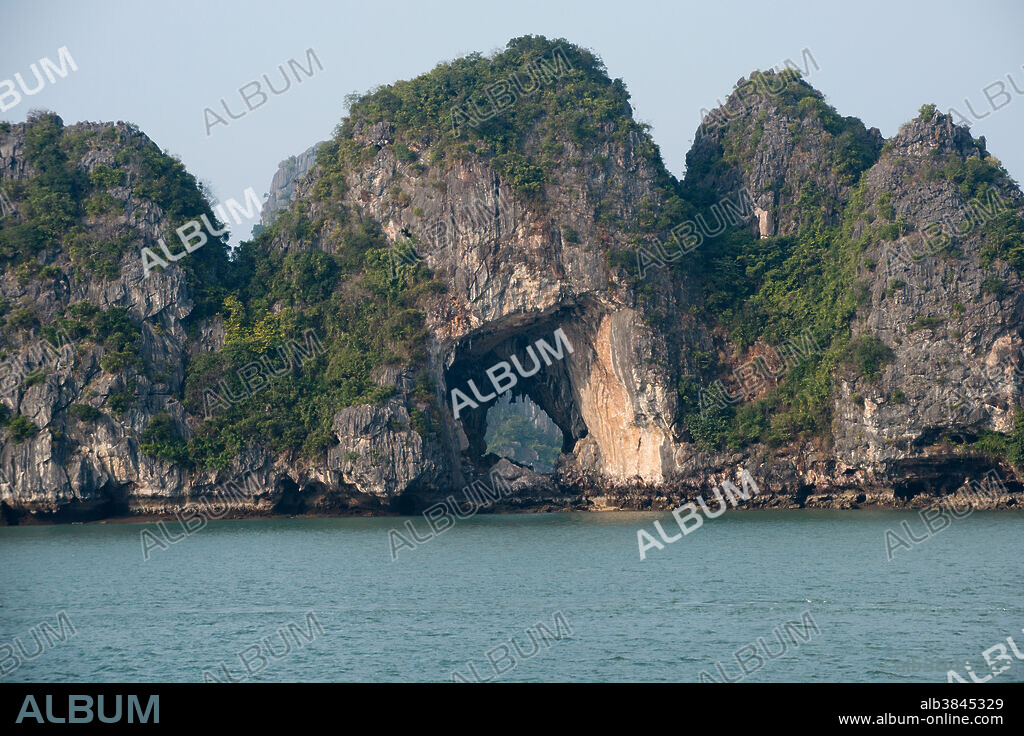 Limestone karst island rising out of the sea, in Halong Bay, Vietnam.