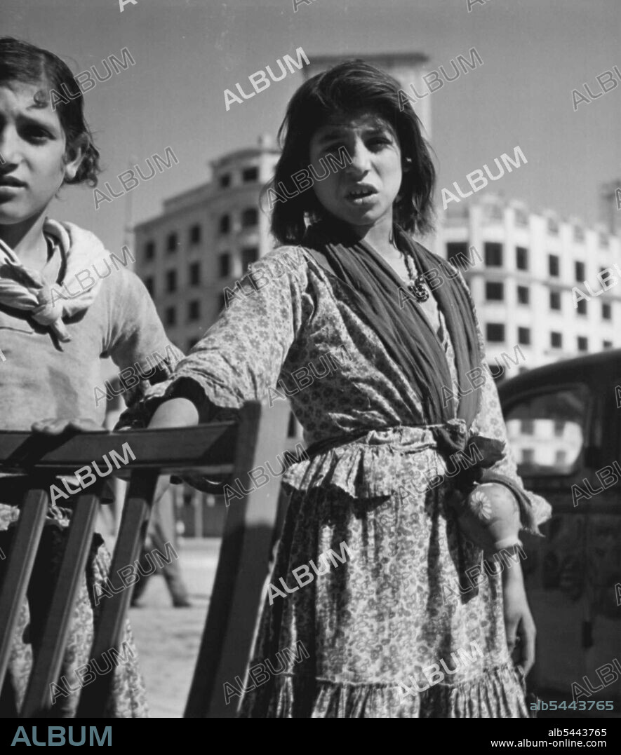 Ragamuffin Showgirl -- "Huh! Old stuff." Poor girl standing by is'nt moved. Maybe she's seen it too often in her district of Barcelona. August 19, 1949. (Photo by Pictorial Press).