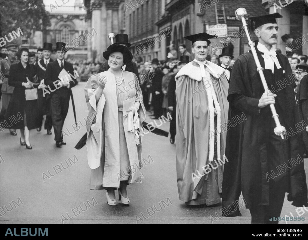 Orig. bildtext...THE QUEEN AT CAMBRIDGE. 21.10.48. The Queen visited Cambridge University today to receive an Honorary Degree as a mark of symbolising and initiating the new status of women in the University to which they have been admitted as full members for the first time. The picture shows the Queen in the procession through the town in her Cap & Gown after receiving the Degree. Anm. E Bowes-Lyon, 1900-2002, brittisk drottning 1936-1952 och maka till kung Georg VI, kallad drottningmoder när äldsta dottern tillträdde som drottning Elizabeth II 1952. Ceremonier Processioner Akademiker Traditionell klädsel Akademisk dräkt Hederstitlar Pärlhalsband Kragar Symboler CD514 persons: ELIZABETH, DROTTNING AV STORBRITANNIEN sites: CAMBRIDGE;STORBRITANNIEN.