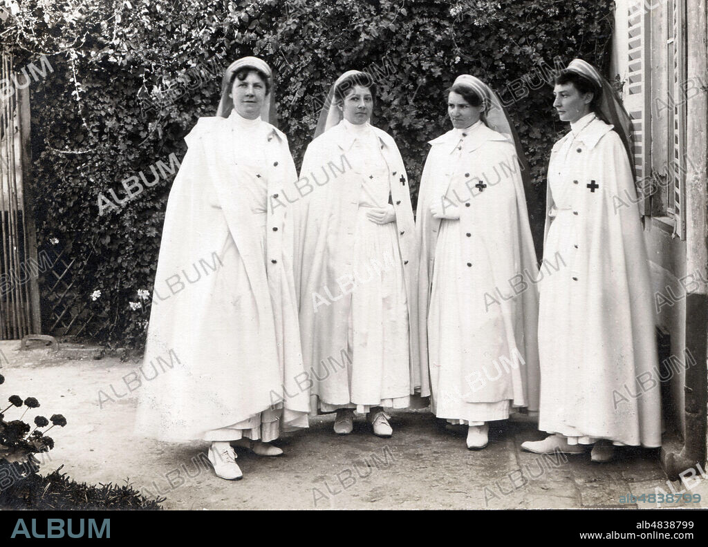 Infirmieres de l'une des trois societes de la Croix Rouge Francaise en tenue de ville, portant la cape blanche pour pays chauds, ici photographiees au Maroc ou en Tunisie. Seule la croix rouge est portee sur la cape. Il existe des modeles plus courts. Les voiles sont d'un modele tres particulier. La photographie a ete prise vers 1910-1913 soit avant la premiere guerre mondiale. Credit Collection F. PINEAU/KHARBINE TAPABOR.