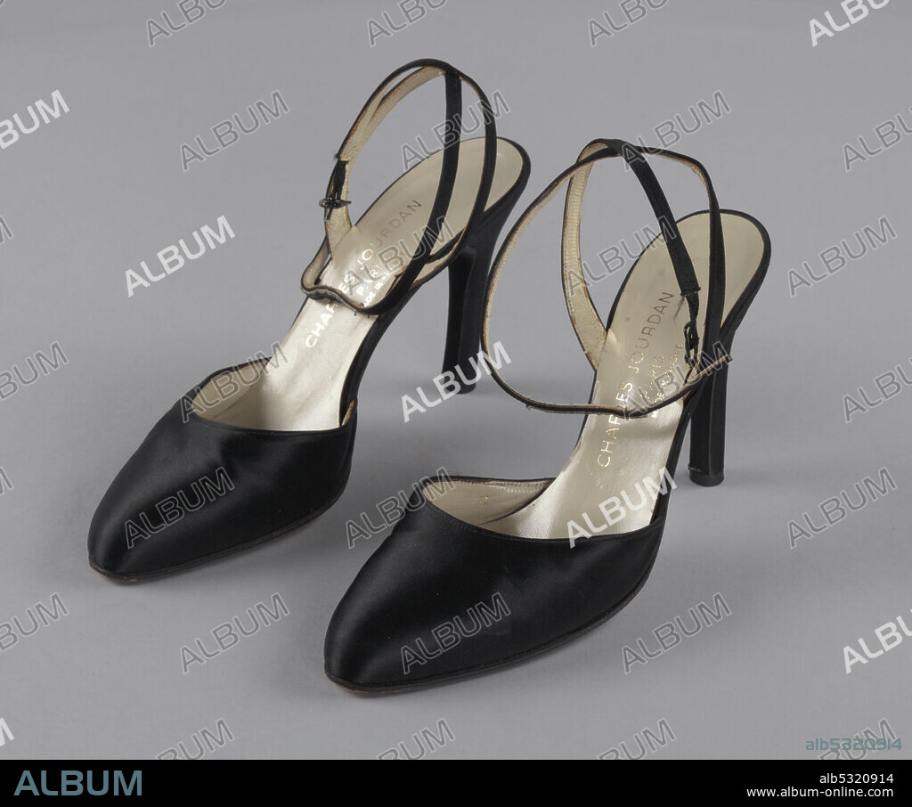 A pair of black satin close-toed shoes with stiletto heels and an ankle strap that is sewn in a cross at the back of the ankle and closes at the exterior of the ankle with a metal buckle. The insoles and the interior of the toes and straps are made from cream colored leather. The bottoms of the shoes are made of wood painted black. Gold type on the insole of each shoe reads "CHARLES JOURDAN / PARIS / MADE IN FRANCE". Mae Reeves (1912-2016) was a pioneering African-American milliner who was famous for her custom-made hats. Her business, Mae's Millinery Shop in downtown Philadelphia, was one of the first shops in the city to be owned by a woman of African American heritage.
