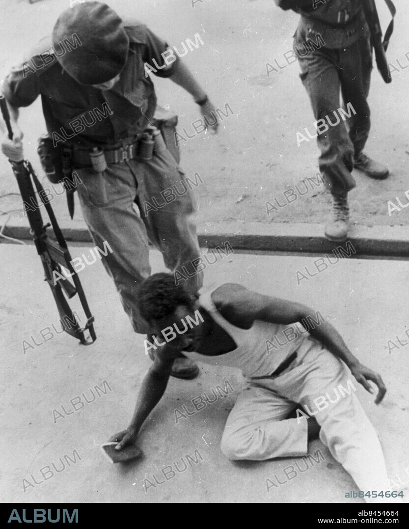 STANLEYVILLE, CONGO NOV. 28th 1964 - A Congolese rebel, - a "Simba" - is given a helping kick along by a mercenary after he was arrested here, November 25, 1964, in the mopping-up operations after the November 24 massacre.. Photo: UPI Code: 450. COPYRIGHT PRESSENS BILD.