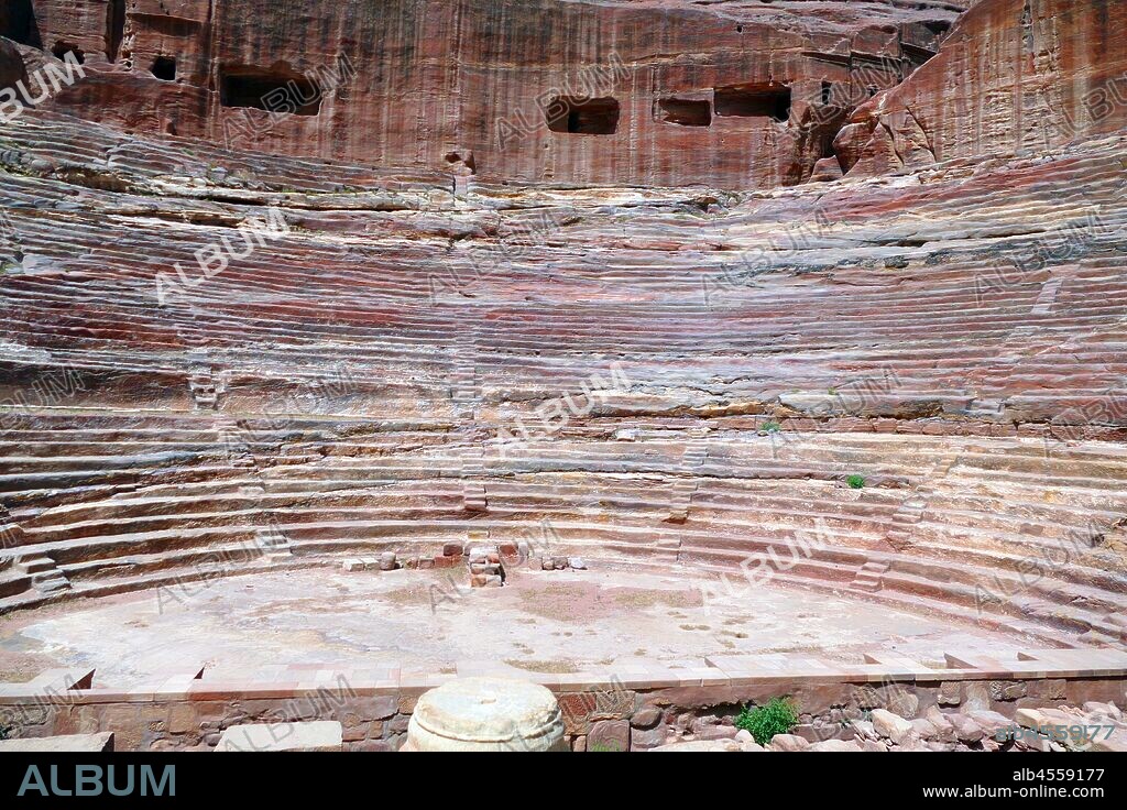 first century AD Nabatean theatre in Petra, Jordan. Substantial part of the theatre was carved out of solid rock, while the scaena and exterior wall were constructed. The theatre's auditorium consists of three horizontal sections of seats separated by passageways and seven stairways to ascend. The theatre could accommodate a number of approximately 8500 people. The theatre was built in the cultural and political apex of the Nabatean kingdom under Aretas IV (9 BC-40 AD), In 1812, the city of Petra and Al-Khazneh was rediscovered by Swiss explorer Johann Ludwig Burckhardt.