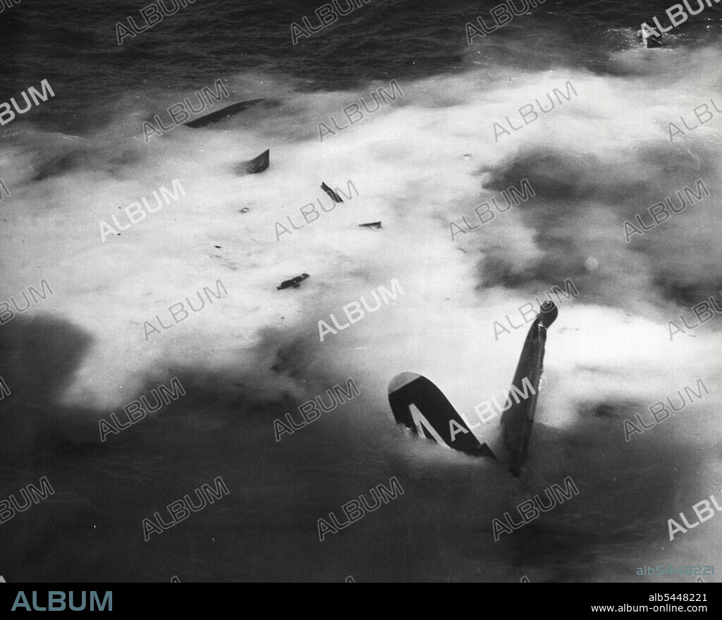 Extra Hazardous Duty - As Boxer's 45,000 tons Knifes past, Lt Jg Droege's plane disintegrates in the water. Droege himself is still under water. As this photo was taken, Droege had unbuckled his safety belt which Kept him from being killed, had shed his crash helmet, and was swimming away from the sinking plane. The helicopter, although not in the photo, is already hovering over the roiled water waiting hopefully for his head to pop up to the surface. In the helicopter with Lt. Buerokkoltz is Crawman L.A. Wight, Chief Aviation Machinists mate of 5520 Peru Place, San Diego, Cal. May 19, 1951. (Photo by Official US Navy Photograph).