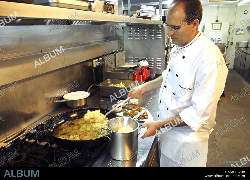 Bar - Restaurante "Teatriz"; jefe de cocina friendo las patatas para la confección de tortilla española.