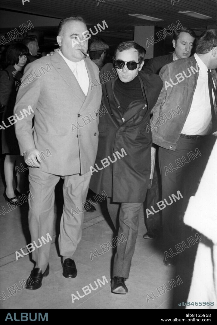 Orig. bildtext... CET HOMME EFFONDRES QUE SOUTIENT BRUNO COQUATRIX: CHARLES AZNAVOUR, RENTRE POUR LES OBSEQUES DE SA MERE. Charles Aznavour est arrivé ce matin á Orly, en provenance des Etate-Unis ovp il était en tournée, afin d'assister aux obsèques de sa mère, décédée récemment á Moscou. Nous le voyons ici, visiblement effondré, chaussant des lunettes noires et soutenu par Bruno Coquatrix ce matin, á son arrivée á Orly. Anm. Solglasögon Svarta kläder Cigarrer Vänner Sorg persons: BRUNO COQUATRIX;CHARLES AZNAVOUR sites: FRANKRIKE.