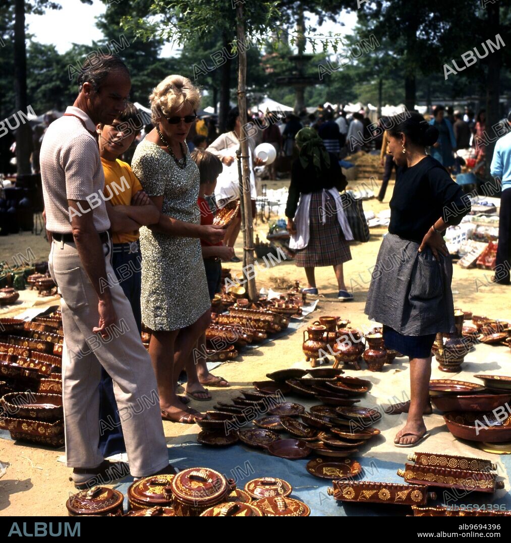 Tourists looking at local pottery for sale at a market in Barcelos , Minho , Portugal.