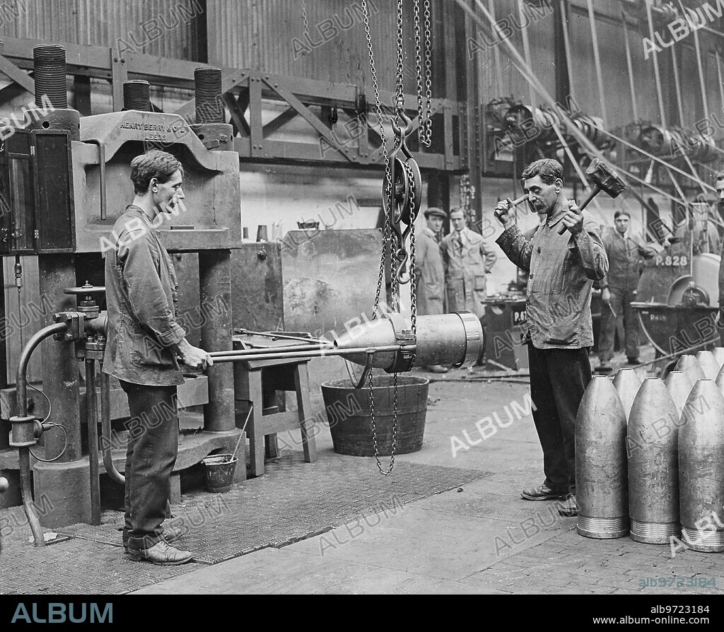 Reino Unido, julio de 1916. Primera Guerra Mundial. La fabricación de municiones de guerra. Colocación de la faja de cobre en una granada de grueso calibre.