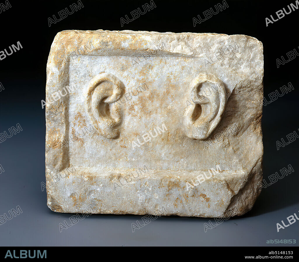 Weihrelief mit zwei Ohren, Marble, chiseled, Total: Height: 24 cm; Width: 29,2 cm; Depth: 8 cm; Weight: 11,9 kg, Reliefs, votive offerings, body parts, Late Classicism (Greek antiquity), The rectangular block has a recessed image field with the representation of a human pair of ears. The back as well as the top and bottom are roughly worked off. The sides were straightened with a toothed chisel. So far, some of these votive reliefs have become known, which were once placed in a sanctuary with the request for healing or as thanks for a recovery from an ear disease granted by the gods. The votive relief was intended for the 'hearing gods' (gr. theoi epekooi). Whether the consecration took place in one of the great healing sanctuaries like Epidauros or Kos can no longer be determined.