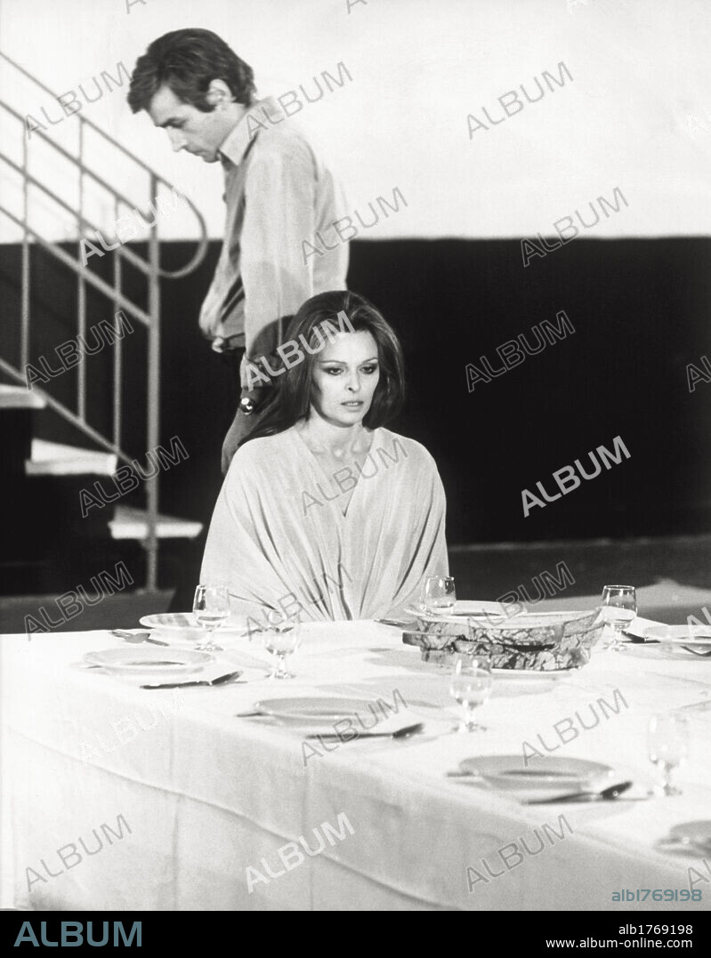 Lucia Bosè and Antonello Campodifiori in 'So long Gulliver' ('Ciao Gulliver'). The Italian actors Lucia Bosè (sat down at a laid table and wearing a white scene costume) and Antonello Campodifiori are playing in a scene of 'So long Gulliver' ('Ciao Gulliver'), directed by Carlo Tuzii. Italy, 1970.