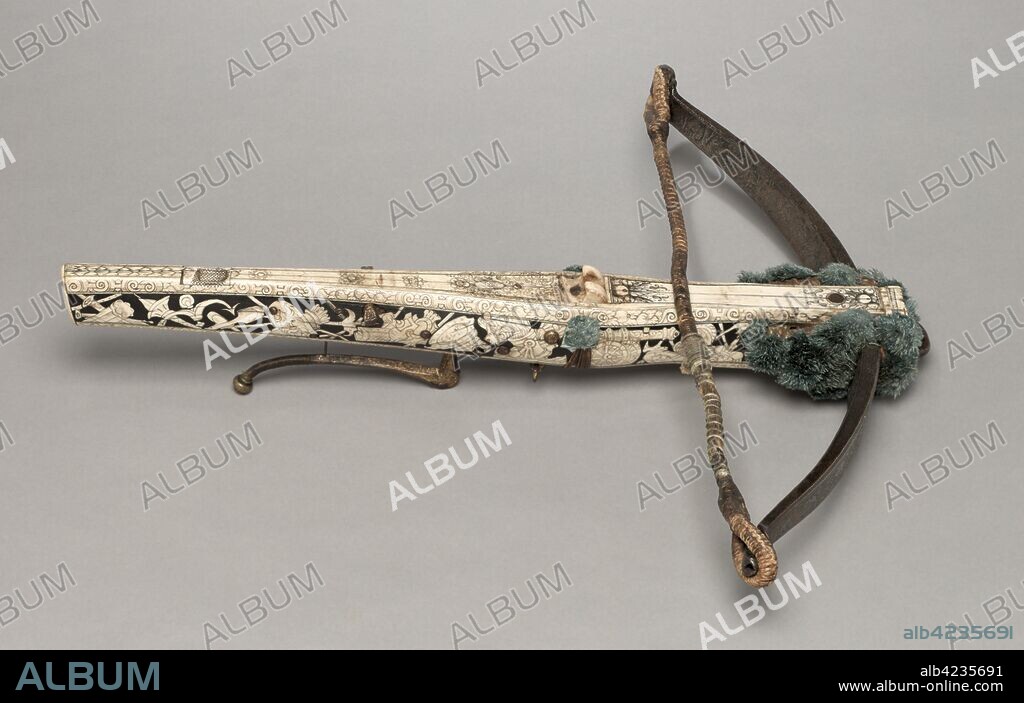 Crossbow and Cranequin of Elector Augustus I of Saxony, c. 1553-1573. Germany, Saxony, 16th century. Wood (walnut?), bone veneers, flax cord, steel (etched, traces of gilding). woolen pompoms, stock decorated wih inlaid trophies of arms; bow: 58.5 cm (23 1/16 in.); butt: 5.7 cm (2 1/4 in.).