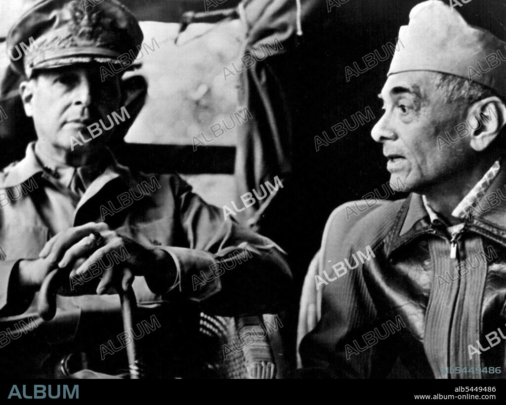 Philippine Chieftains In Conference : Wearing an overseas cap, President Manuel Quezon of the Philippines is shown, right, as he confers with General Douglas MacArthur at field headquarters during the first days of the "battle of Luzon. Picture is one of the first to arrive from the Philippine arena of combat. August 22, 1942. (Photo by Interphoto News Pictures, Inc.).