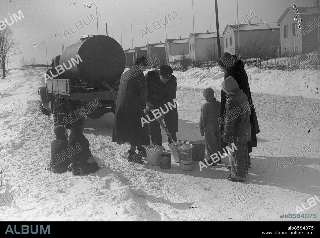 GÖTEBORG 1942-03-19.. Vattenbrist i Lundby - Dysiksgatan söderut. Kvinnor hämtar vatten i kastruller och spänner från en tankbil. *** Local Caption *** GT Foto: Kamerareportage / TT / Kod: 2524.