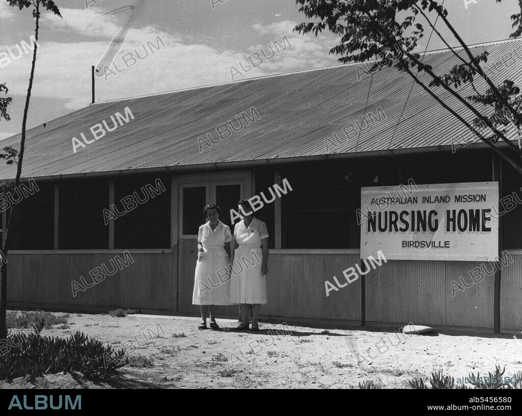 New, £15,000 hospital operated by the Australian Inland Mission was opened in Birdsville in August, 1953, after the original hospital had been destroyed by a fire two years earlier.Pictured at left are two of the handful of white women in the town, Sister V. Roden (left) and Sister L. McKay outside the hospital. Birdsville is also a base for the Flying Doctor Service. Patrol Padre Les McKay, who succeeded the late Dr. John Flynn to the Flying Doctor Service, is pictured (above) with two native patients at the hospital, Topsy and Alice.The aerial photograph shows the complete township, while the one and only street, Adelaide Street, is shown (second from top).These exclusive pictures were taken by a Telegraph photographer who flew into Australia's outback with the Royal Geographical Society. November 25, 1955. (Photo by The Telegraph Newspaper Co. Ltd.).
