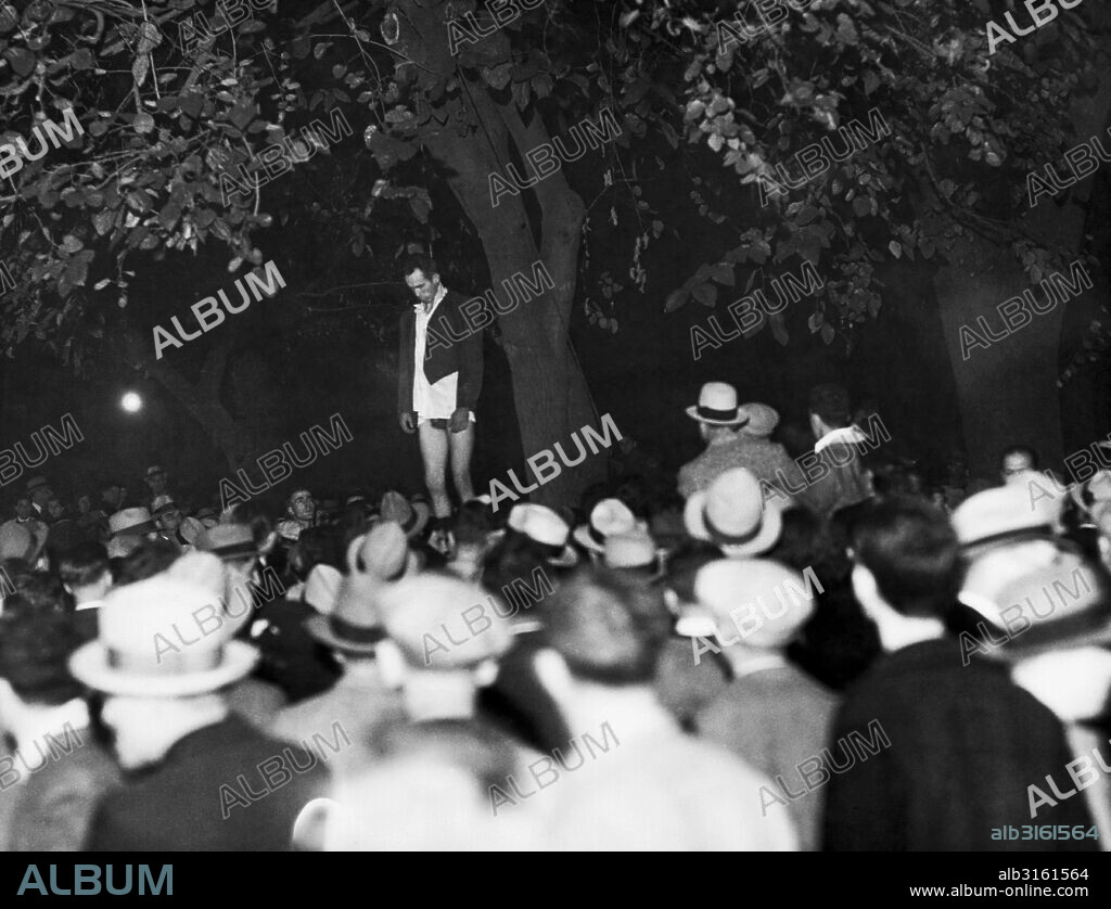 San Jose, California: November 27, 1933. The body of Thomas Thurmond, alleged kidnaper and slayer of Brooke Hart, shown after a mob which dragged him from the county jail, completed its work. He was beaten and hanged from a tree in St. James city park, 100 yards from the jail. John Holmes, his alleged accomplice, was strung up a few minutes later.