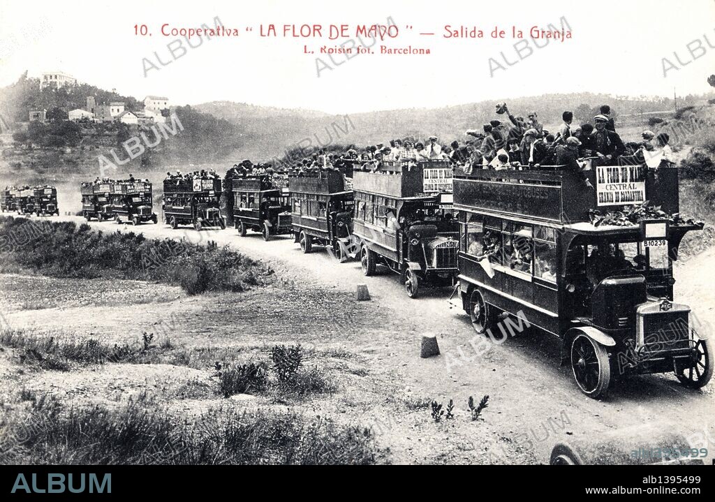 Tarjeta postal. Cooperativa La Flor de Mayo en Cerdanyola (Barcelona). Salida de la granja de la caravana de vehículos. Años 1920.