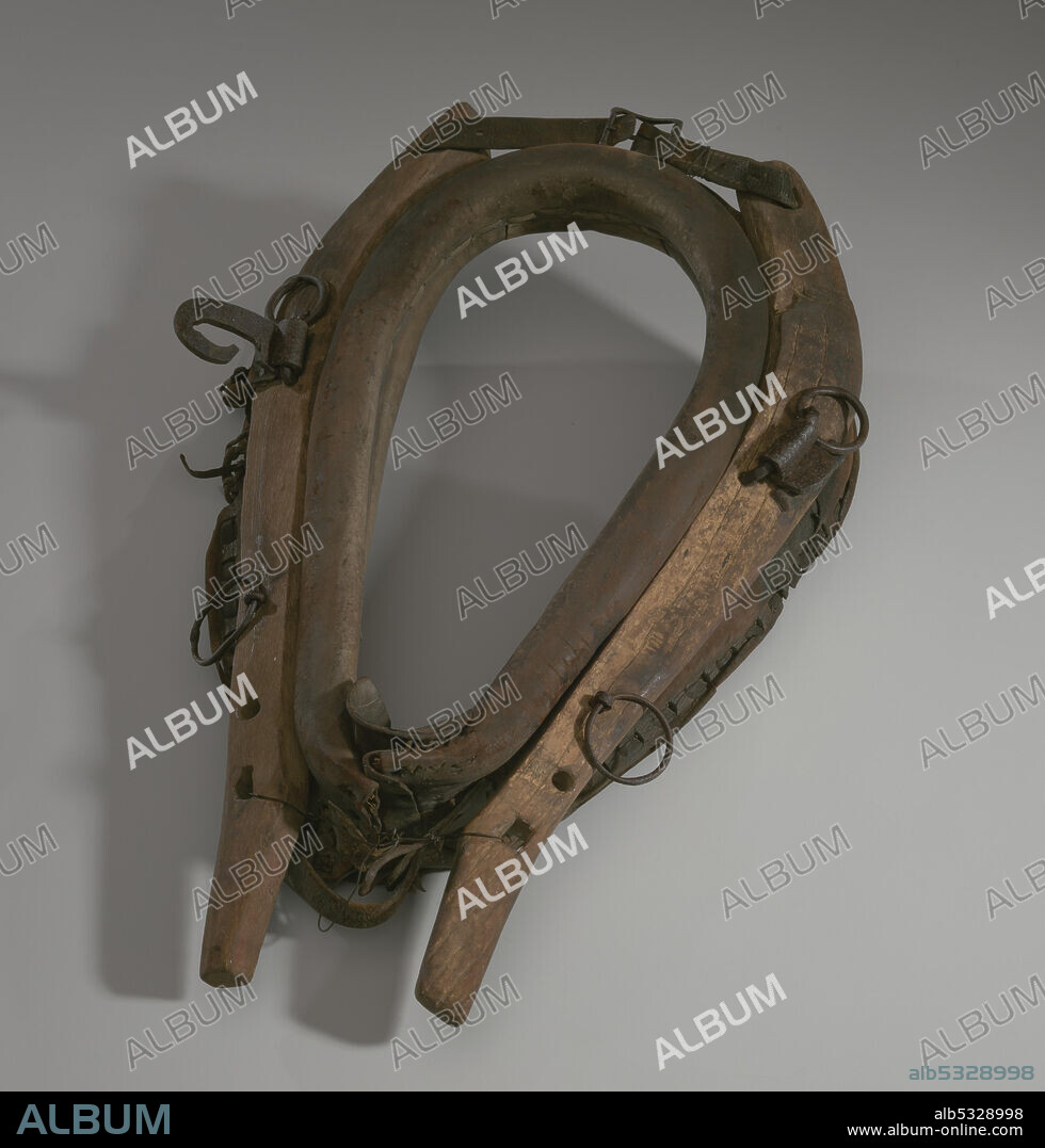A horse collar owned by Morton Lyles. The collar is made of leather stuffed with straw. The collar is attached to horse hames. The hames are made of wood frame and have two buckles, one at the top and one at the bottom that allow the hames to attach to the collar. The hames have four metal rings and a metal hook attached to both right and left sides of the wood. The collar fit around a horse's neck and shoulders and attached to a harness.
