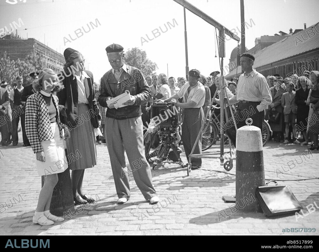 Juni 1940.. Filminspelning 'Vi Masthuggspojkar' - trogen på Masthuggstorget - regissören Nils Jerring med skådespelerskan Gaby Stenberg och okänd flicka *** Local Caption *** GP. KAMERAREPORTAGE.