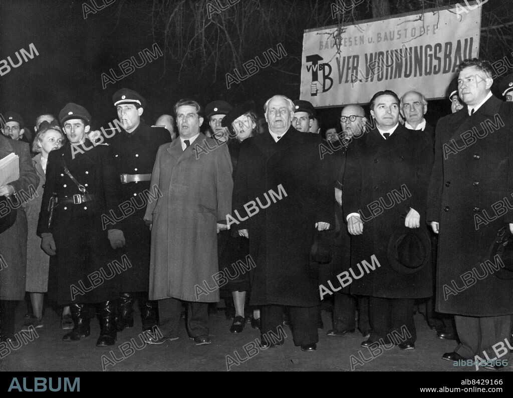 Orig. bildtext... BERLIN STREET NAMED STALIN ALLEE IN HONOUR OF RUSSIAN LEADER'S BIRTHDAY 23-12-49 The 70th birthday of Marshal Stalin, Russian leader, was celebrated in the Soviet Sector of Berlin on Wednesday and in honour of the occasion, Berlin's longest street, Frankfurter Allee was renamed, Stalin Allee. Parades were held in the newly christened highway with a fireworks display in the evening. Photo shows: During the renaming celebrations, on Wednesday, seen third from the right is President of the East German People's Democracy, Wilhelm Pieck, and left of him, Hans Jendretzky, Chairman of the Berlin SED, with top police officers singing the International. Anm. W Pieck, 1876-1960, tysk politiker, Östtysklands president 1949-1960 H Jendretzky, 1897-1992, tysk politiker Namnbyten CD715 persons: WILHELM PIECK;HANS JENDRETZKY sites: ÖSTBERLIN;ÖSTTYSKLAND.