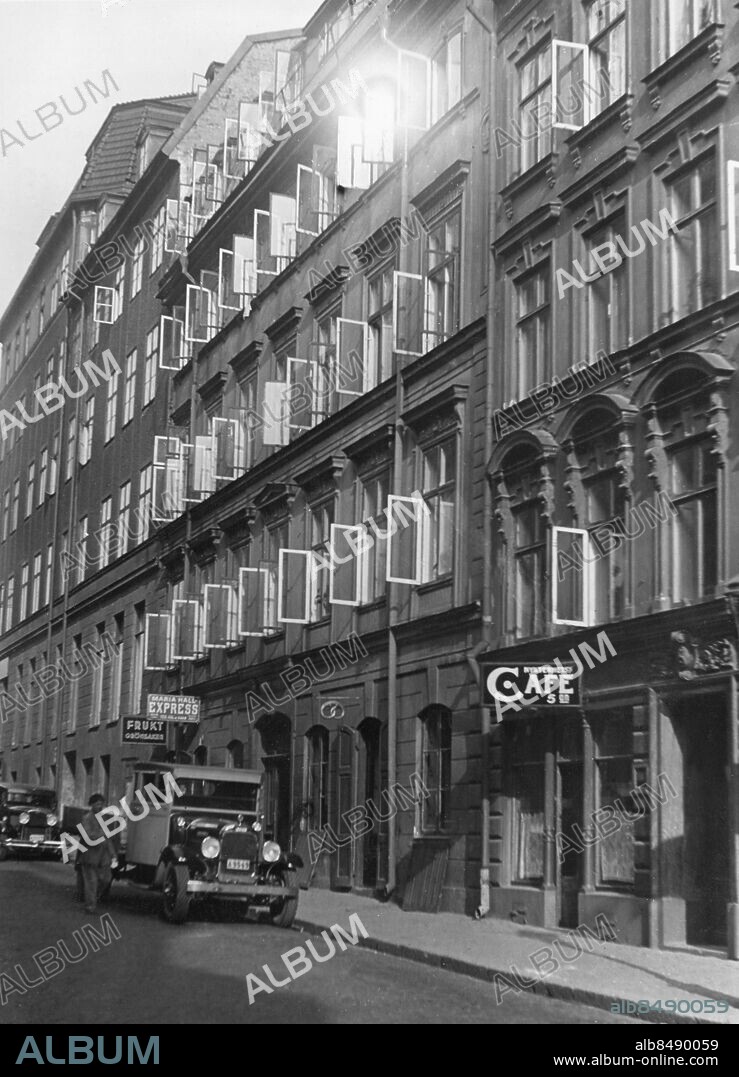 STOCKHOLM OKÄNT FOTODATUM.. Orig. bildtext... VÄGGLUSPROBLEMET är så brännande att det faktiskt är mera brännande än brandfrågan själv, yttrade häromdagen en fackman i en intervju i en morgontidning. Ett försäkringsbolag för täckande av riskerna vid förekomst av väggohyra lär också vara under planläggning. Icke bara ett stort antal våningar utan till och med stora huskomplex i olika delar av staden stå för närvarande under cyanväterökning. Bild I visar den igenbommade porten till ett hus, som cyanväterökes. De stackars lunschgästerna /se skylten/ få under tiden söka placera sig på annat håll. Bild II Efter cyanväterökningen gäller det att vädra ordentligt... Bild III och IV:... och piska kläder, mattor och sängkläder mycket noga. Anm. Se även BBT432 samt BBT434-BBT435 Bildserier Fotoreportage Fasader Öppna fönster Vädring Skyltar Nykterhetscafé Maria Halls Express Skadedjur Ohyra Löss CD520 sites: STOCKHOLM;SVERIGE.